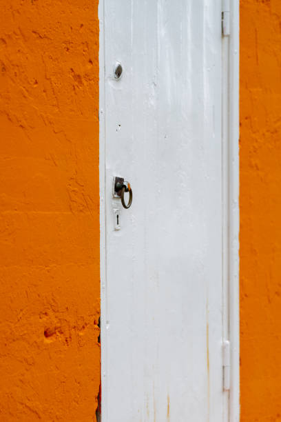 istock Orange and white painted door, closed with a handle and a keyhole 1601372891