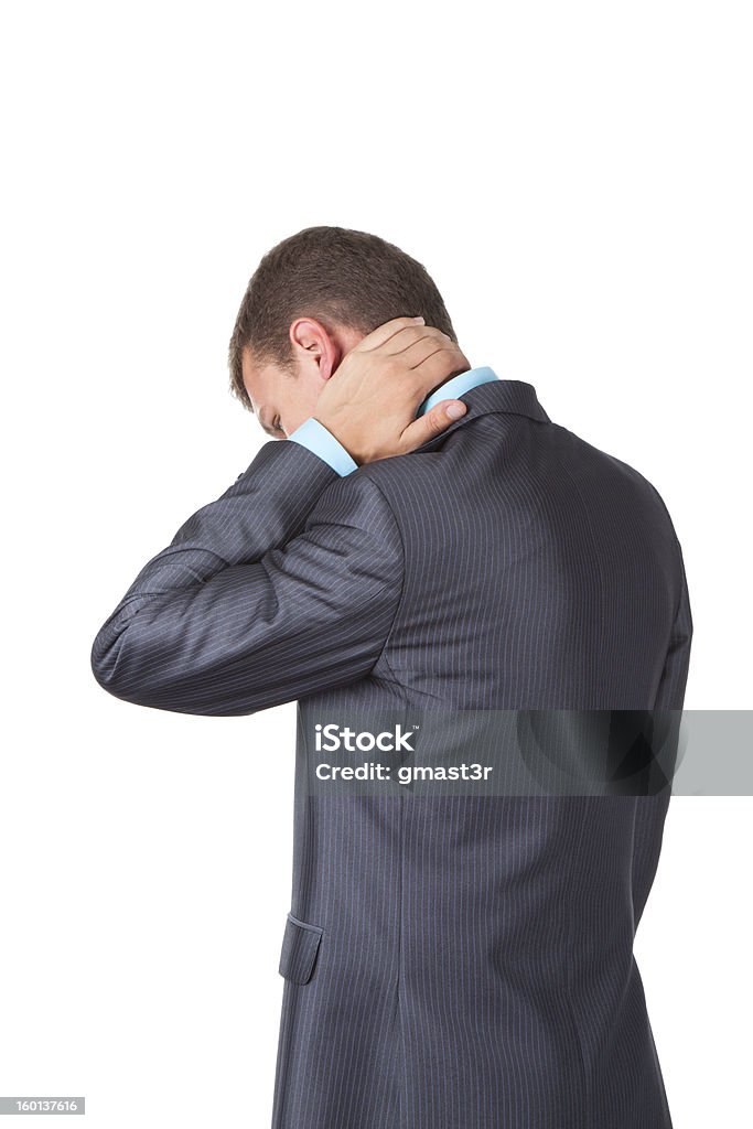 Businessman neck pain Handsome young business man in modern elegant suit standing back holding hand on neck, isolated over white background. Concept of neck or head ache, pain, problem, tired up. Adult Stock Photo