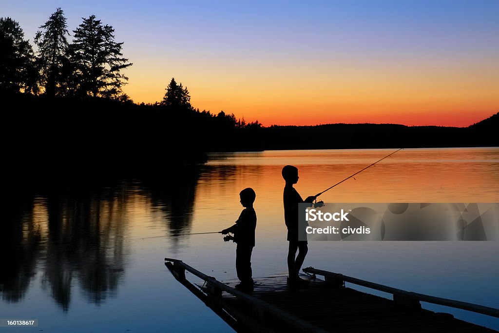 Ragazzo pesca al tramonto - Foto stock royalty-free di Pesca - Attività all'aperto
