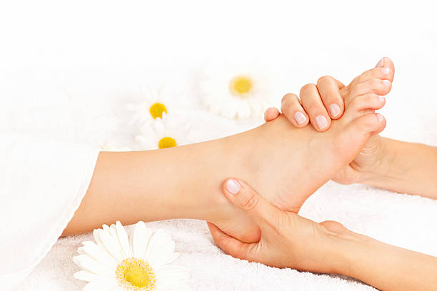 massagem nos pés - reflexology pedicure massaging human foot imagens e fotografias de stock