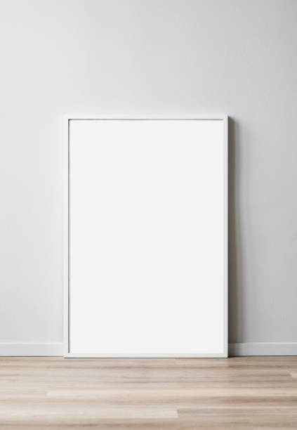 istock Artwork mockup in interior design. White blank picture frame on a wooden floor. Vertical orientation 1601391881