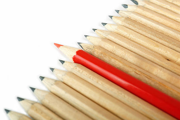 istock Row of rough graphite pencils with color red one 160139189