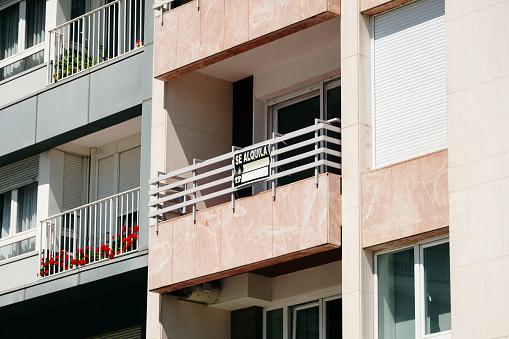 A 'Se alquila' (for rent) sign in an apartment building in Spain