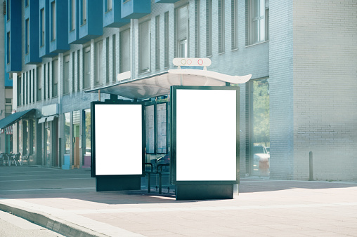 A bus stop in a modern city with two blank posters / billboards