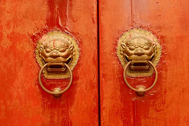 red Chinese temple doors with bronze lion knobs red Chinese temple doors with bronze lion knobs shingon buddhism stock pictures, royalty-free photos & images