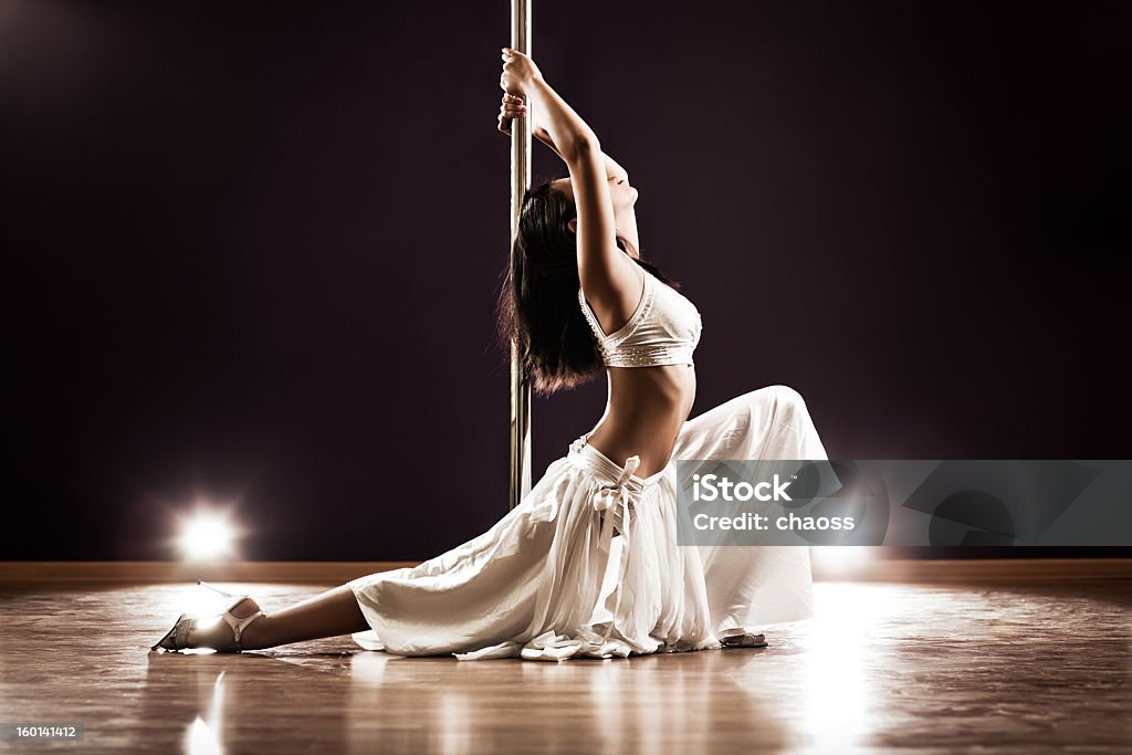 Woman dressed in white pole dancing Young slim pole dance woman. Contrast colors. 20-29 Years Stock Photo