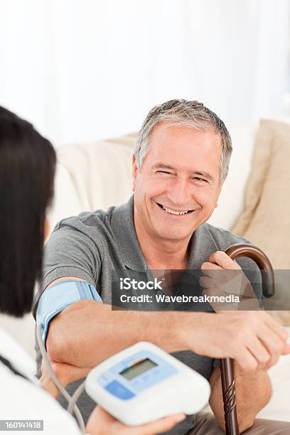 Nurse Taking Blood Pressure Of Her Patient Stock Photo - Download Image Now - Adult, Adults Only, Care