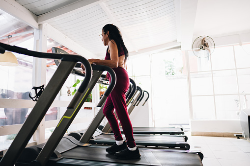 Senior woman using treadmill at the gym