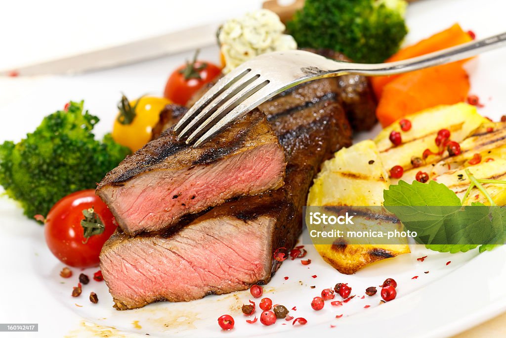 Grilled New York Strip Steak Grilled New York Strip Steak. Baked Potato Stock Photo