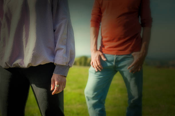 Man and woman, young couple standing in front of each other in nature. A nice sunny day in spring or autumn.