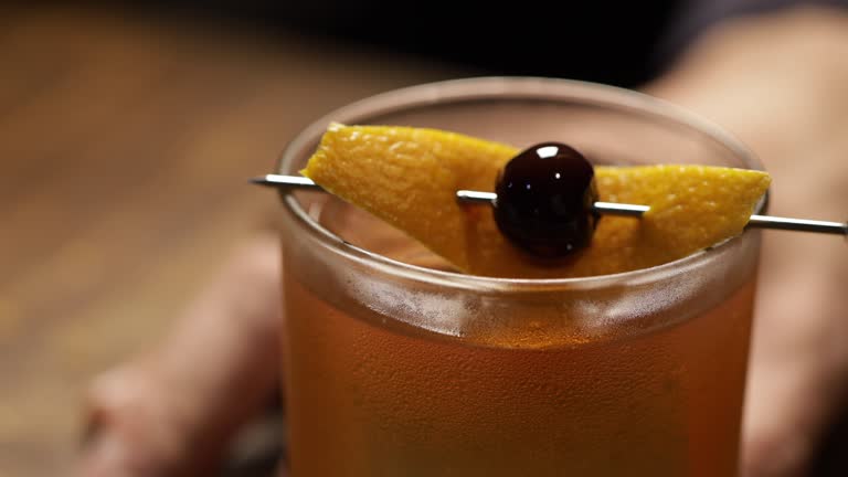 Old-fashioned cocktail served on a wooden bar table