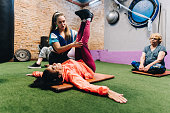Teacher helping student during stretching class at the gym