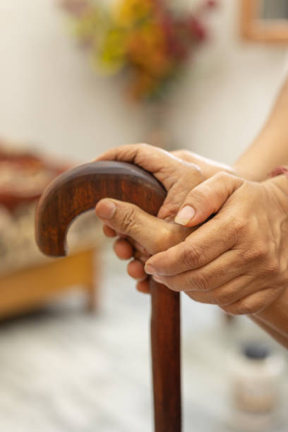 杖に傾いた先輩の手を握る女性のクローズアップ - human hand aging process senior adult cane ストックフォトと画像