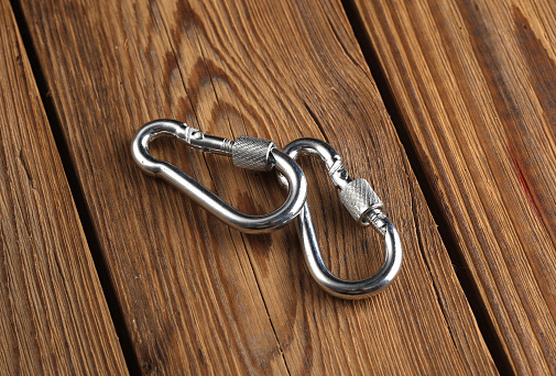 Metal carabiners on a wooden planks