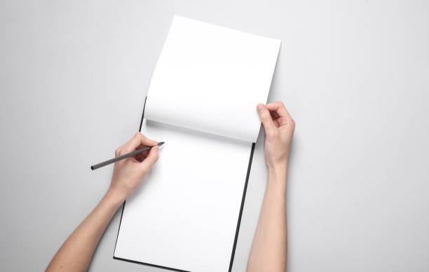 istock Female hands write on a blank sheet in clipboard on a gray background 1601448920