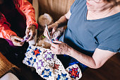 Senior friends crocheting at home
