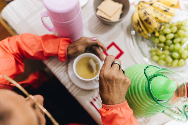 High angle view of a senior preparing tea during breakfast at home