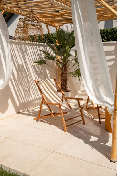 istock Boho Sun chairs under driftwood pergola by the swimming pool in warm sunlight 1601537585