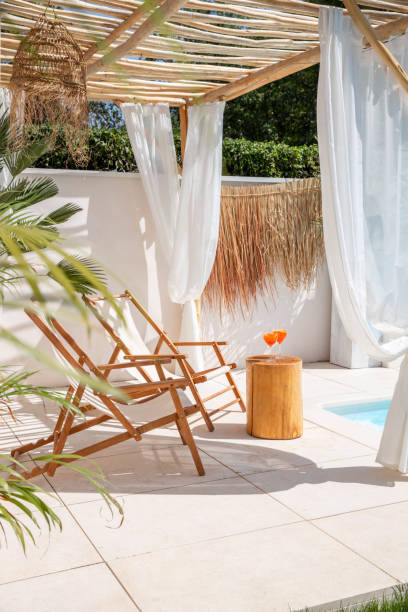 istock Sun chairs with orange refreshment drinks Spritz glasses by the pool in warm sunlight 1601539219
