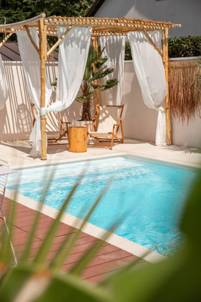 istock Boho Sun chairs under driftwood pergola by the swimming pool in warm sunlight 1601540231