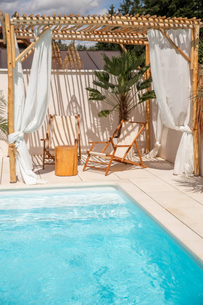 istock Boho Sun chairs under driftwood pergola by the swimming pool in warm sunlight 1601540283