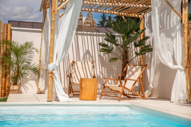 istock Boho Sun chairs under driftwood pergola by the swimming pool in warm sunlight 1601540284