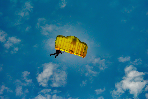 Paraglider in the blue sky. The sportsman flying on a paraglider.