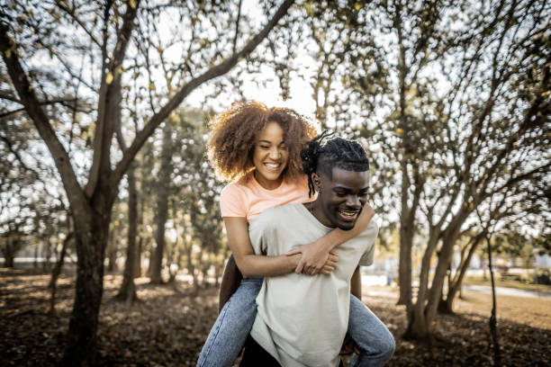 istock Young couple doing piggyback at a park 1601550701