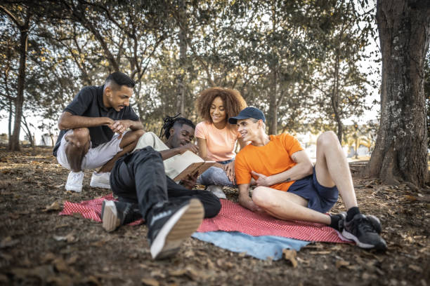 istock Young man with friends taking notes or drawing at a park 1601551250