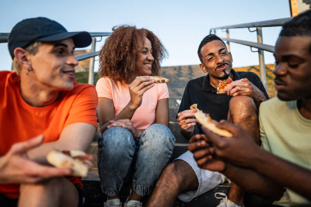 istock Friends sharing a pizza outdoors 1601554007