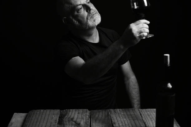 istock sitting man drinking wine face expression black and white photo with silhouette 1601570277