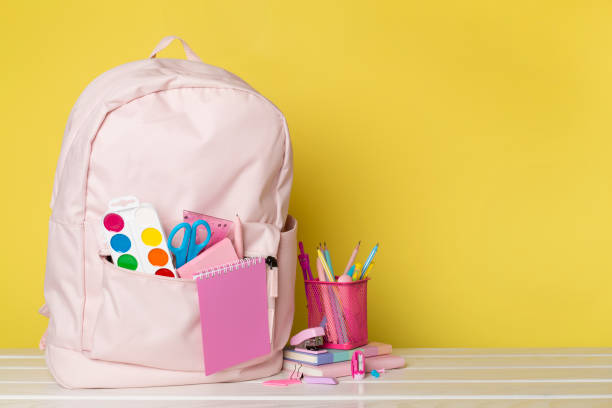 istock Pink school backpack with stationery on wooden table 1601577235