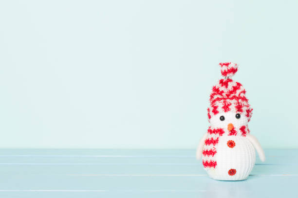 Small Christmas snowman on wooden table.