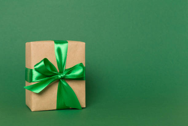 istock Gift box with green ribbon bow on color background 1601587700