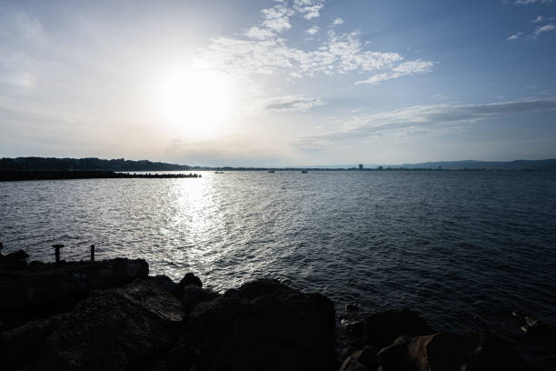 Sunset on the sea with rocks and blue sky in the background.