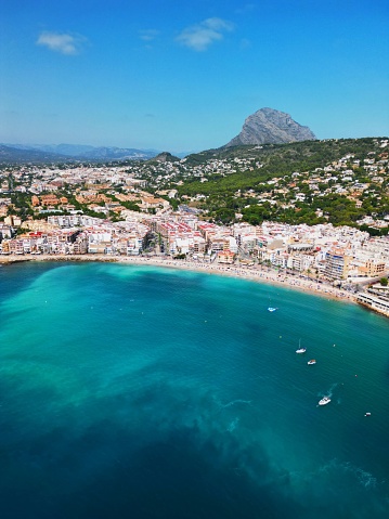 A tranquil beach with several small boats bobbing lazily in the water on Javea Port