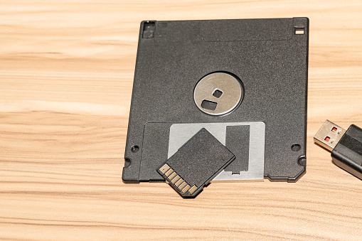 Photography of varios media storage device on brown wood background.