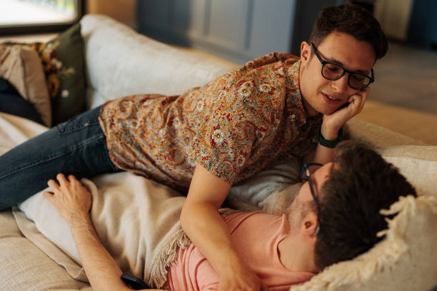 istock Romantic gay couple on sofa. 1601657757