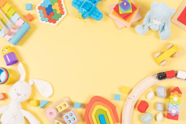 istock Baby kids toy frame background. Wooden, plastic, educational, musical, sensory, sorting and stacking toys for children on yellow background. Top view, flat lay, copy space 1601659331