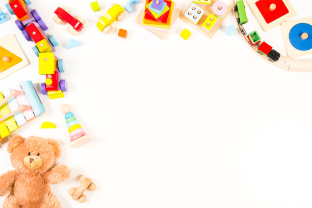 istock Baby kids toys frame background. Teddy bear, wooden educational, sensory, sorting and stacking toys, wooden train, colorful building blocks on white background. Top view, flat lay 1601659844