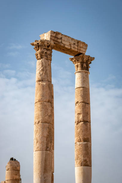 Ruins of Roman Hercules Temple with its cloumns on Citadel Hill in Amman, Jordan against blue sky with clouds