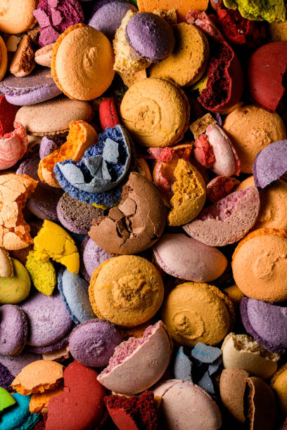 istock Whole and broken colorful homemade macaroons laying chaotically. Overhead view. Square image 1601767320