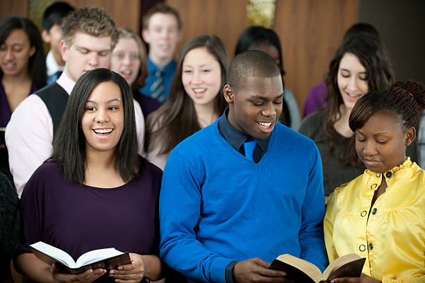 Singing hymns A diverse group of young adults singing in church. - Buy credits sing praise stock pictures, royalty-free photos & images