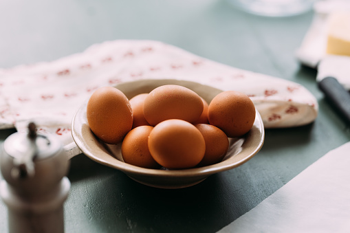 A close up view of a bowl of eggs on the kitchen table.