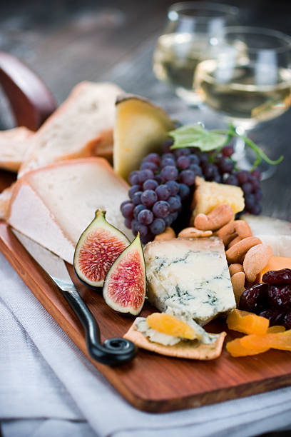 Cheese and Wine A delicious cheese plate with fruits and wine. artisanal food and drink stock pictures, royalty-free photos & images
