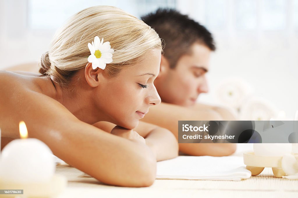 Young couple enjoying themselves at the spa centre A beautiful couple relaxing themselves at the spa centre with their eyes closed. White background.    Adult Stock Photo