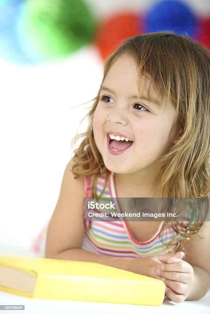 Girl having fun laughing girl with book 12-17 Months Stock Photo