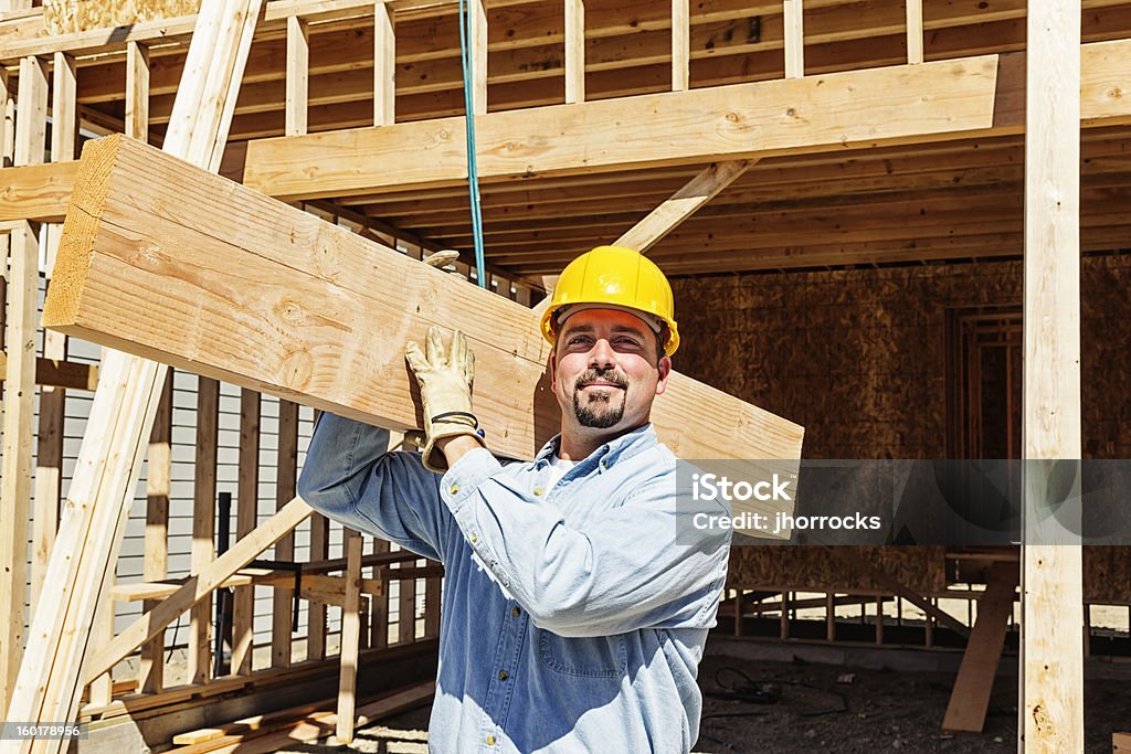 Trabajador de la construcción de la viga transporte de madera - Foto de stock de Llevar libre de derechos