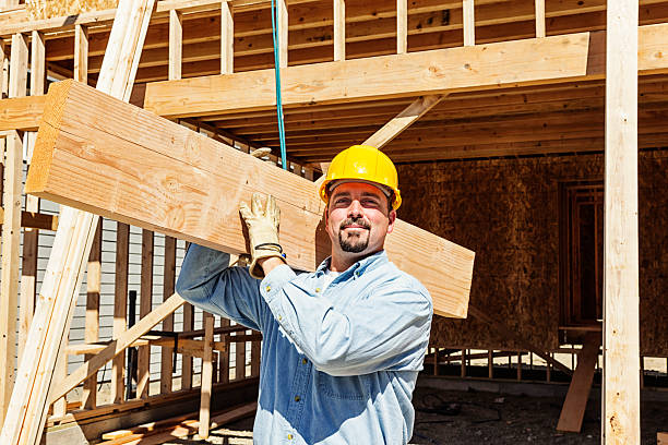 construction travailleur transportant des poutres en bois - architecture blue business carrying photos et images de collection