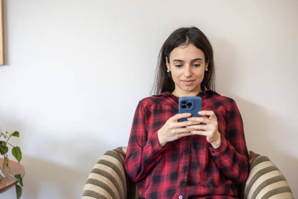 istock Caucasian woman using cell phone at home 1601791333